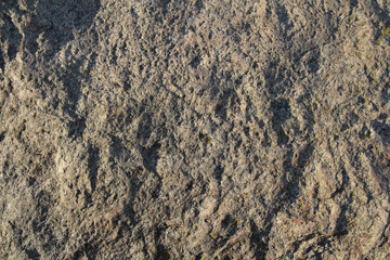 A stone surface with cracks, spots, irregularities. Heterogeneous natural texture. Stock photo for web and print with empty space for text and design, backgound, wallpaper, scrapbooking