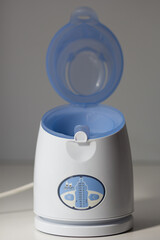 Digital baby food and bottle warmer with open cap on the white background