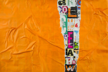 Torn and crumpled orange paper on colorful collage from clippings with letters and numbers texture...