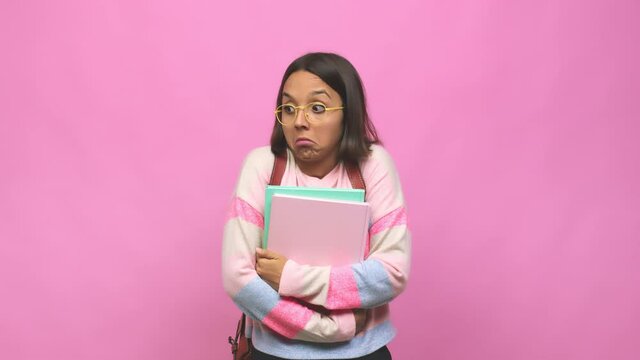 Young student indian woman shrugs shoulders and open eyes confused