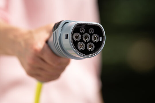 Close Up Of A Hand Holding An Electric Car Charger