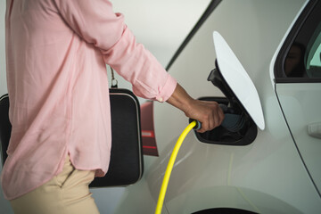 Close up of a woman's hand charging a electric car