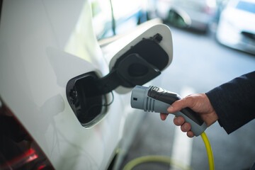 Close up of a man's hand holding a electric car charger