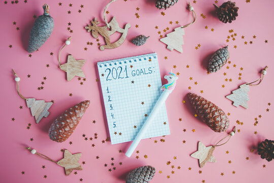 Holiday decorations and notebook with 2021 goals, plans, dreams. New Year and Christmas concept. Flat lay. Top view.