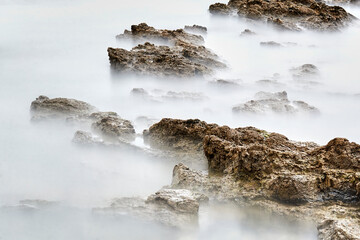 Long exposure photography with a neutral density filter. Beach in Asturias, Spain with a cloudy sunrise.