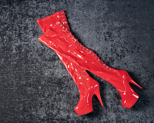 Kinky red high lacquer boots on a dark chic background