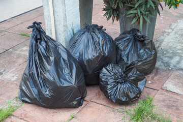 Black garbage bags big and small Completely sealed, 4 bags are placed on the cement floor.