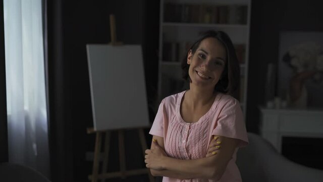 Middle aged woman with short brown hair smile at the camera while standing in the apartment. Emotion concept. High quality 4k footage