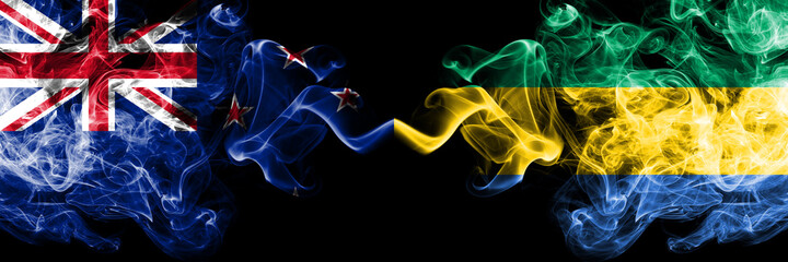New Zealand vs Gabon, Gabonese smoky mystic flags placed side by side. Thick colored silky abstract smoke flags