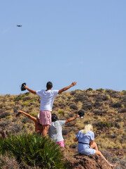 Group of cheerful friends taking pictures and video of themselves in a natural environment