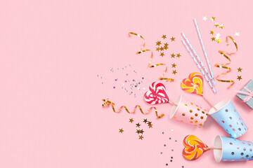 Obraz na płótnie Canvas Birthday party supplies on pink background. Top view. Copy space.
