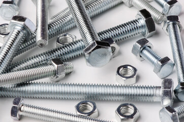 Lots of metal bolts and nuts. Tool for fixing. White background
