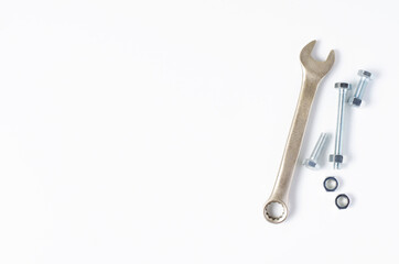Wrench and bolts with nuts. White background. Copy space