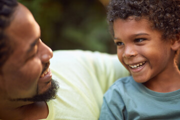 afro-american father and son talking ooking each other, smiling