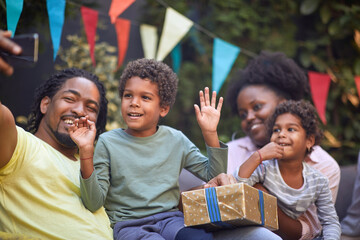  afro-american dad taking selfie with his family. little boy with hands up