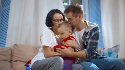 Mother, father and little son at home spending time together