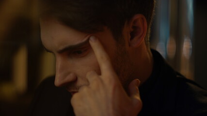 Young man face looking camera indoors. Handsome guy thinking inside.