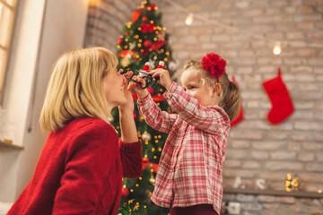 Mother and daughter wearing Christmas party glasses