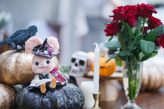 Happy Halloween. A Cute Bunny Felt Doll In A Wicken Witch Costume Sitting On A Black Pumpkin. Decoration Props For Trick Or Treat Candy Hunt Time For Children.