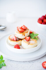 Cottage cheese cheesecakes with strawberries and powdered sugar, dessert