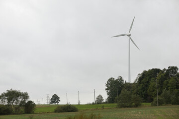Fototapeta premium Wind turbines field in a stormy day with strong wind and rain. Wind farm eco field. Green ecological power energy generation.