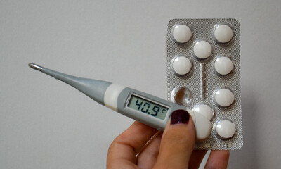 Thermometer showing high temperatures and medicines to control it. White background