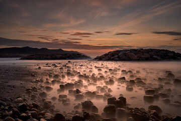 Landscape of a sunrise on the beach with rocks © DAVID