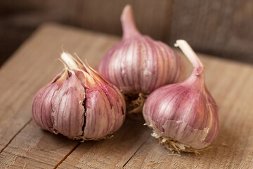Three garlic on a wooden background.