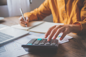  business person sitting at a desk at an office By using the calculator to work. Business Concept...