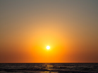 Romantic sunset by the sea. The setting sun over the waves.