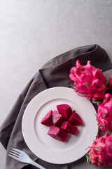A Plate of dragon fruit served on concrete table.