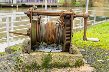 A disused boat-winch next to a river-harbour.