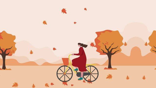 Young woman riding a bicycle in fall autumn park