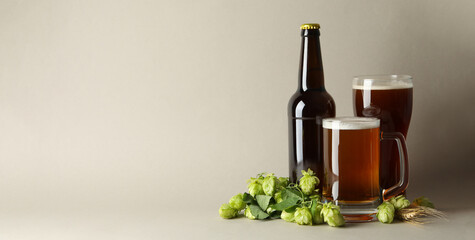 Beer and green hop on gray background