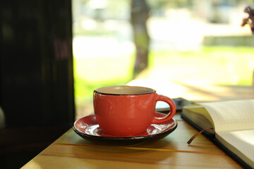Cup of coffee, notebook and phone on wooden table