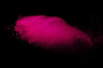 Pink powder explosion on black background. Paint Holi.