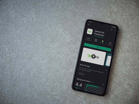 Lod, Israel - July 8, 2020: Upwork for Freelancers app play store page on the display of a black mobile smartphone on ceramic stone background. Top view flat lay with copy space.
