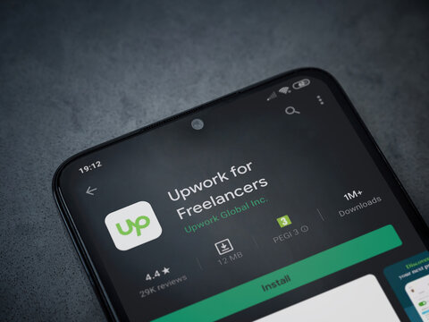 Lod, Israel - July 8, 2020: Upwork for Freelancers app play store page on the display of a black mobile smartphone on dark marble stone background. Top view flat lay with copy space.