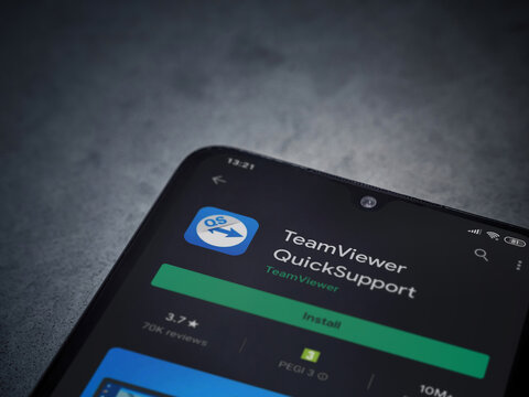 TeamViewer QuickSupport app play store page on the display of a black mobile smartphone on dark marble stone background