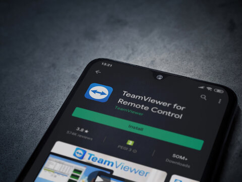 Lod, Israel - July 8, 2020: TeamViewer app play store page on the display of a black mobile smartphone on dark marble stone background. Top view flat lay with copy space.
