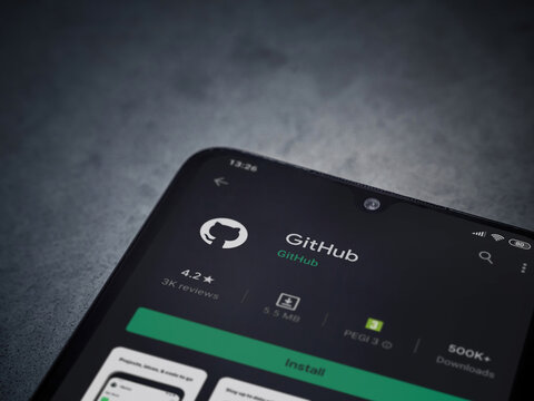 Lod, Israel - July 8, 2020: GitHub app play store page on the display of a black mobile smartphone on dark marble stone background. Top view flat lay with copy space.