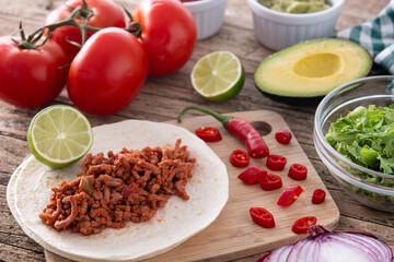 Mexican tacos ingredients on wooden table	