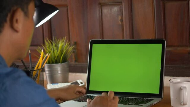 Computer laptop with blank green screen chroma key.