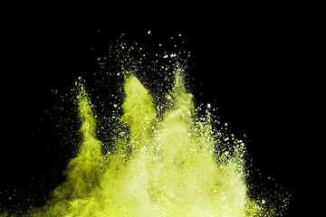 Yellow powder explosion isolated on black background.