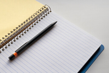 Naklejka premium Open spiral notebook and black pencil. Copy space for text
