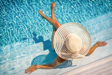 Tuinposter woman in luxury spa resort near the swimming pool. © Netfalls