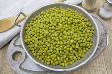 plat de petits pois cuits sur une table en bois