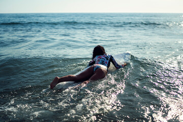 Joven atractiva con tabla de surf practicando en cadiz
