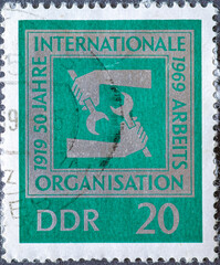 .GERMANY, DDR - CIRCA 1969: a postage stamp from Germany, GDR showing hands with wrenches. Text: 50...