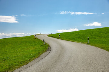 Landstrasse in grüner hügeliger Landschaft